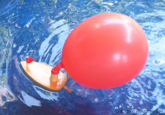Luftballonboot Der Luftballon an einem Holzboot. Die ausströmende Luft treibt das Boot an.