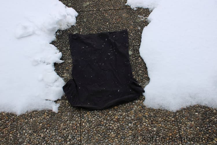 Schwarzes T-Shirt im Schnee.