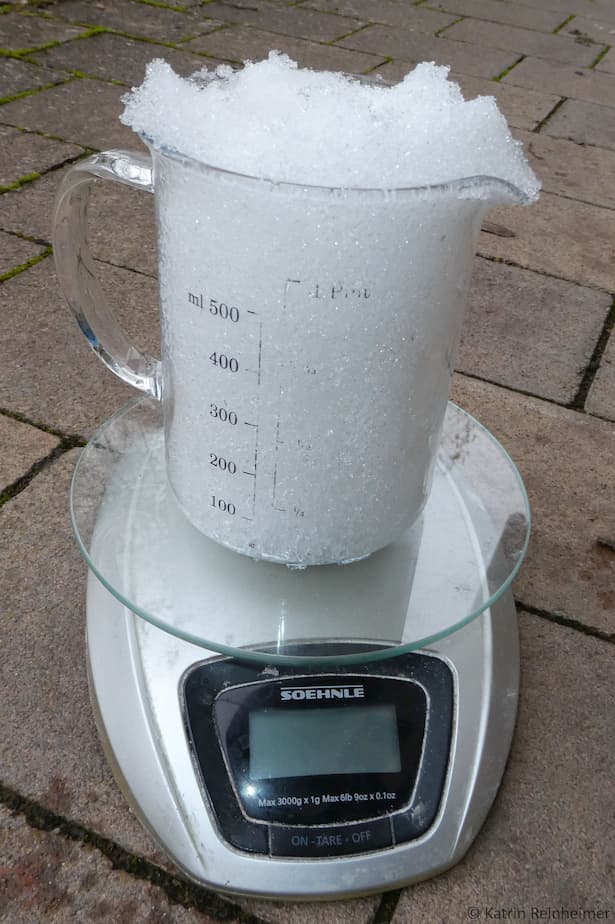 Der mit Schnee gefüllte Messbecher wird gewogen.