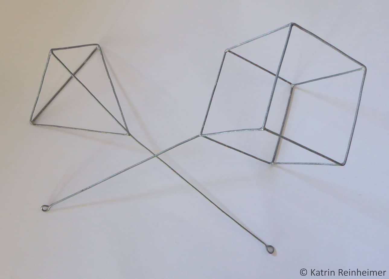 Eine Pyramide und ein Würfel aus Draht zur Darstellung von Minimalflächen mit Seifenlauge.