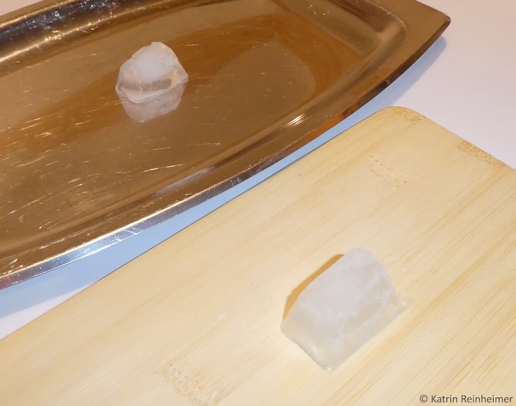Eiswürfel auf Metall und Holz.
